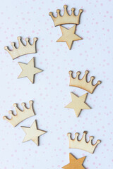 star and crown wooden embellishments arranged on scrapbook paper