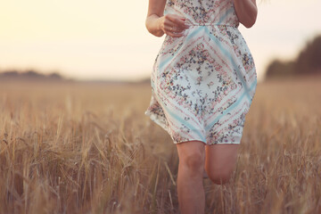 girl runs through an agricultural field summer