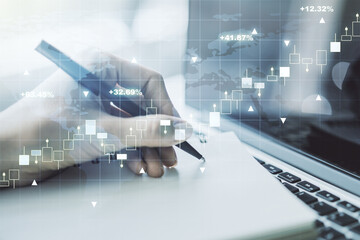 Abstract creative financial graph with world map and with hand writing in notebook on background with laptop, forex and investment concept. Multiexposure