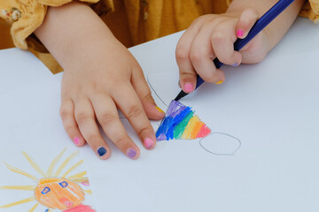 European kid girl painting with colored pencil. Kindergarten children education concept. Close-up of children's drawing.