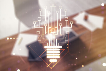 Creative light bulb with chip hologram and modern desk with computer on background, artificial Intelligence and neural networks concept. Multiexposure