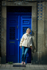 A woman near the front door of an tipical portugal apartment building.