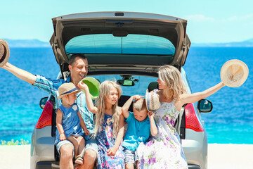 Fototapeta na wymiar A happy family by car by the sea in nature weekend travel