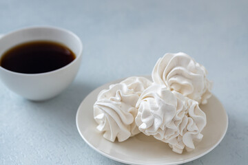 Homemade zephyr or marshmallows with a cup of coffee on a gray concrete background