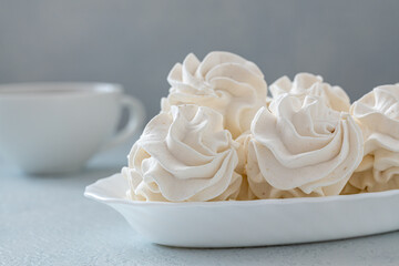 Homemade zephyr or marshmallows with a cup of coffee on a gray concrete background