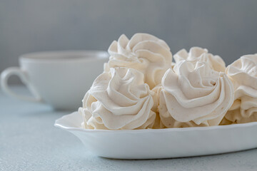 Homemade zephyr or marshmallows with a cup of coffee on a gray concrete background