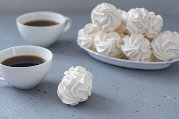 Homemade zephyr or marshmallows with a cup of coffee on a gray concrete background