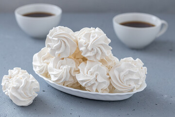 Homemade zephyr or marshmallows with a cup of coffee on a gray concrete background