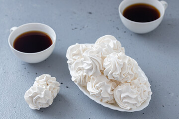 Homemade zephyr or marshmallows with a cup of coffee on a gray concrete background