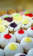 Round donuts stuffed with cream, chocolate and raspberry jam on the shelf in the delicious donut shop. copy space