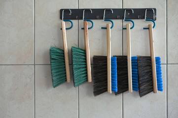 Five brushes for cleaning hanging on wall
