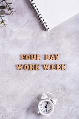 Four day work week concept with wooden letters on desk top and vertical view