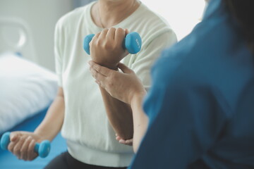 Physiotherapist man giving exercise with dumbbell treatment About Arm and Shoulder of athlete male patient Physical therapy concept