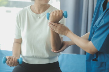 Physiotherapist man giving exercise with dumbbell treatment About Arm and Shoulder of athlete male patient Physical therapy concept