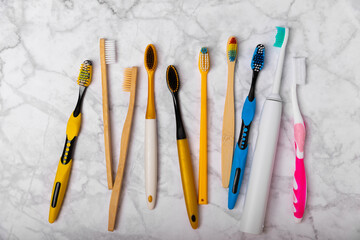 Electric and manual toothbrushes on a marble background. View from above. Oral hygiene. Ordinary toothbrush, eco and electric toothbrush. Oral hygiene. Oral Care Kit. Dentist concept. Dental care. 