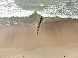 waves and sand with footprints from the high point