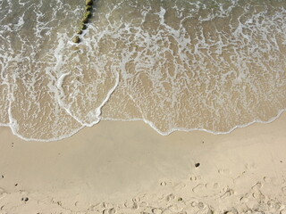 waves and sand with footprints from the high point