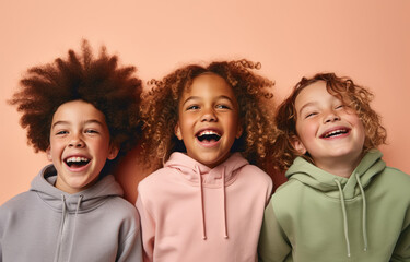 Three children in hoodies with smiling faces, kids have fun in their studio group shots, concept of peace, harmony, friendship, family and hope.