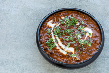 Obraz na płótnie Canvas Dal Makhani Punjabi dish made of whole black lentil and adzuki bean, topped with coriander and cream.