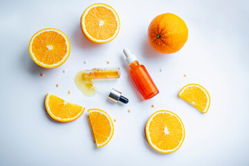 Fototapeta na wymiar Vitamin C face skin care cosmetic concept - organic serum in a bottle and orange slices on white background.