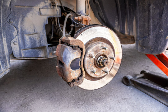 Worn used car brake disk close up. Changing wheels and brakes.