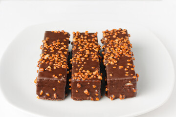 waffle bars with chocolate and nuts on a white plate, copy space