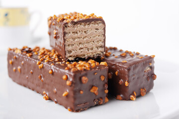 glazed wafer bars with nuts on a white background, close-up, selective focus