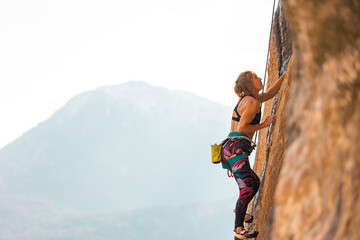 The sports girl is engaged in rock climbing