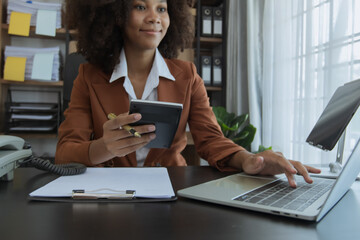 African American businesswoman working at office workplace, Female coworkers discussing project at laptop, professional at workplace. 