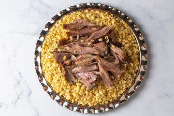 Turkish foods; lamb shank tandoori on bulgur wheat rice (Turkish name; bulgur bugday pilavi kuzu incik tandir)