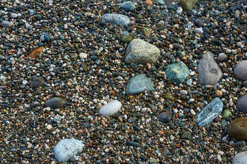 View of small colored pebbles on the seashore.