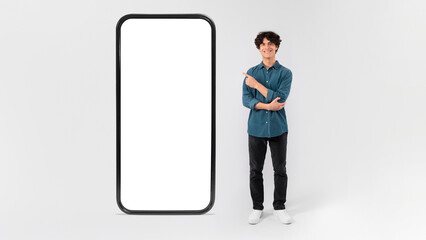 Guy Pointing At Phone Screen Showing App Space, White Background