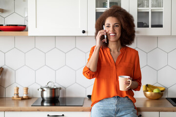 Mobile Call. Happy Black Millennial Woman Talking On Cellphone In Kitchen