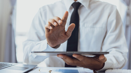 Business man hands using digital tablet at office desk, Business financial planning and technology concept.