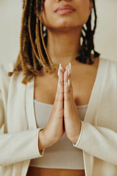 Cropped image African American woman standing, keeping hands in namaste asana position.