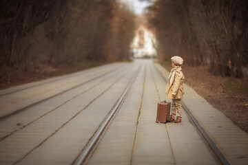 Boy with suitcase waiting for the train