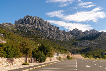 asphalt highway, cars rush to leave. green mountain natural landscape under blue sky. Croatian nature.