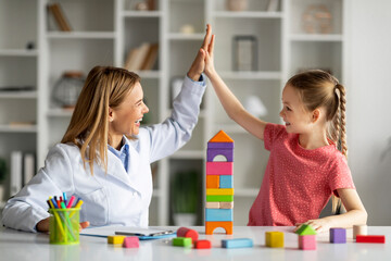 Little Girl Giving High Five To Child Development Specialist, Celebrating Successful Therapy