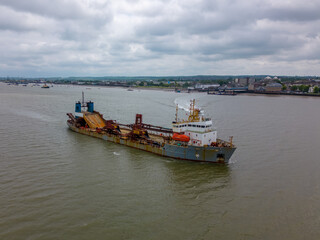 This aerial drone photo shows a cargo ship in the Tilbury docks. The vessel is sailing on the river Thames in England. 