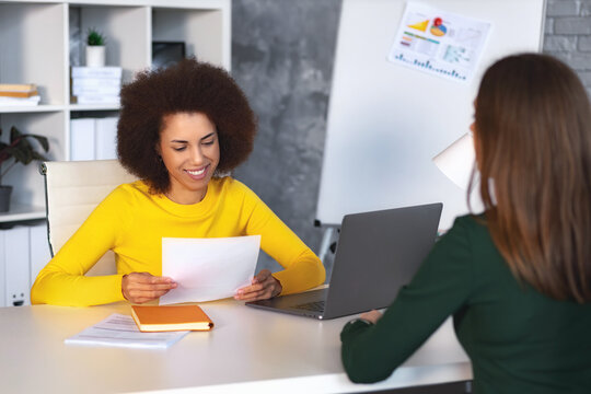 Caucasian female person having a job interview with a African American woman recruiter. Recruitment manager talking, hiring for job new employee sitting in office