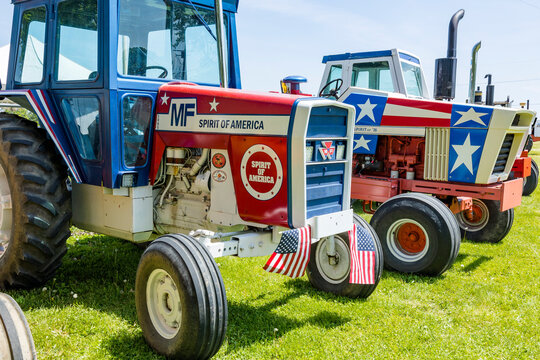 Close-up of Massey Ferguson and Case tractors painted red, white, and blue with stars and American flags.
