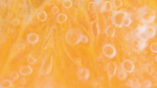 Sparkling water with orange slice. Macro shot of an orange slice in sparkling water. Close-up of an orange slice in carbonated water.
