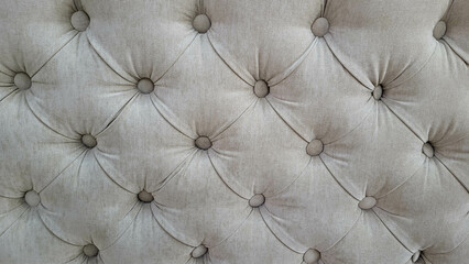 Grey velour background with quilted upholstery in Chesterfield style close-up.