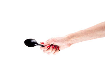 Black plastic spoon in female hand isolated on white background