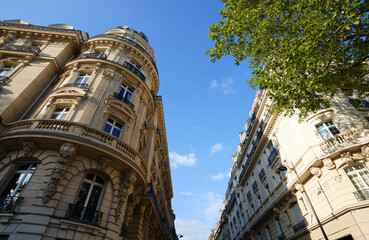 Fototapeta na wymiar The facades of traditional French houses with typical balconies and windows. Paris.