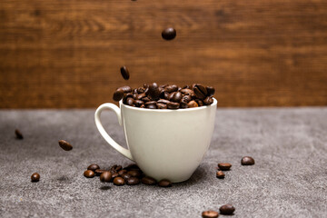 グレイの石模様背景のコーヒー豆とコーヒーカップ