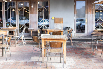 Empty street cafe with terrace with tables and wooden chairs. Street vintage exterior of restaurant. Furniture for coffee shop in street in Europe. Typical view of Parisian street with tables of cafe	