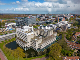 Aerial drone photo of office buildings in Leiden, the Netherlands. The office buildings are next to a large road. 