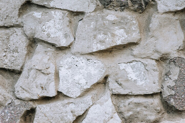 Background, texture of a wall made of vintage gray uneven stones. Photography, architecture.