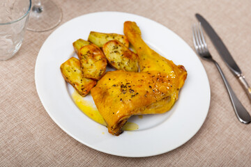Appetizing chicken thighs with baked potato slices served on platter
